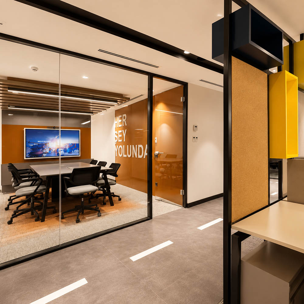 Modern office meeting room with demountable glass partitions, black frames, and solid wall panels