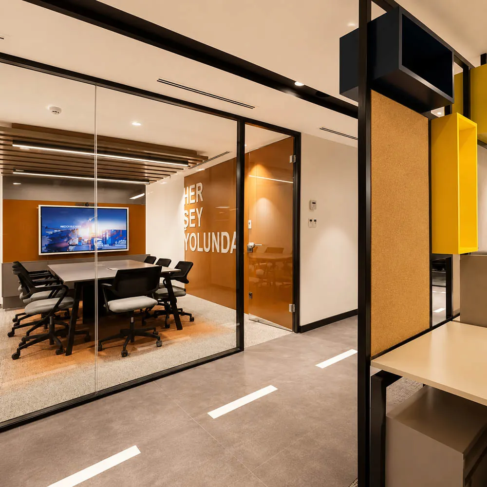 Modern office meeting room with demountable glass partitions, black frames, and solid wall panels