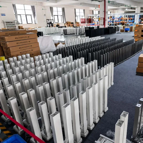 rows of height adjustable table lifting columns and packaged components in a production area