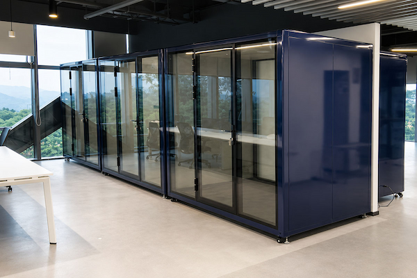 completed row of dark blue office pods after on site assembly for the shenzhen multi floor office project