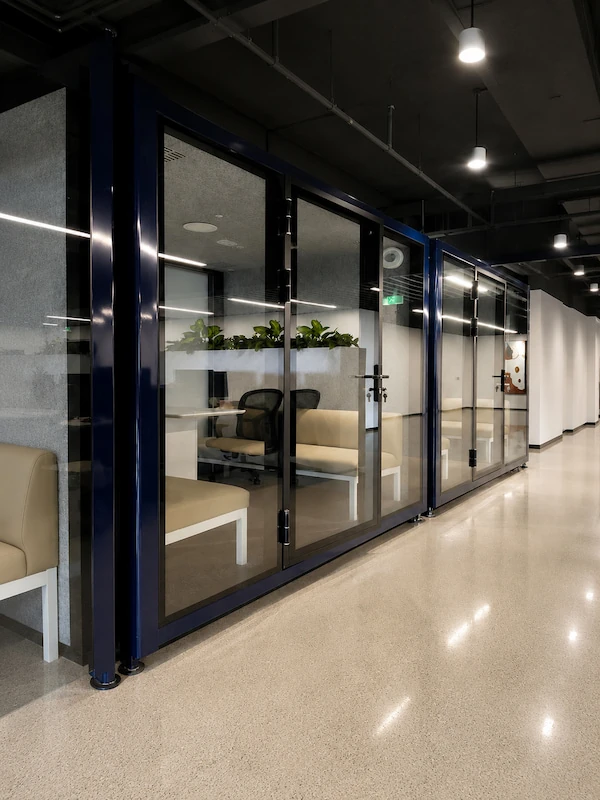 dark blue glass front office pods with bench seating installed along an office corridor in shenzhen