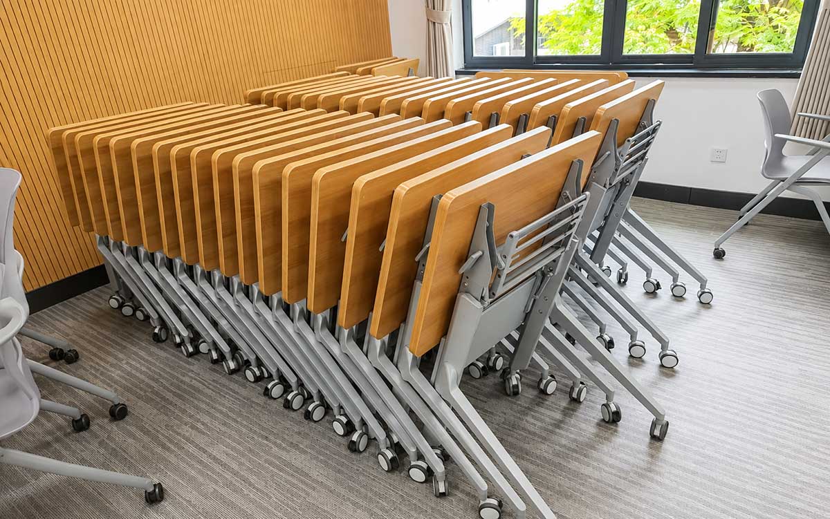 Mobile flip-top training tables nested together for compact storage