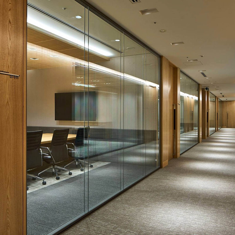 glass and wood demountable wall system installed in a commercial office corridor