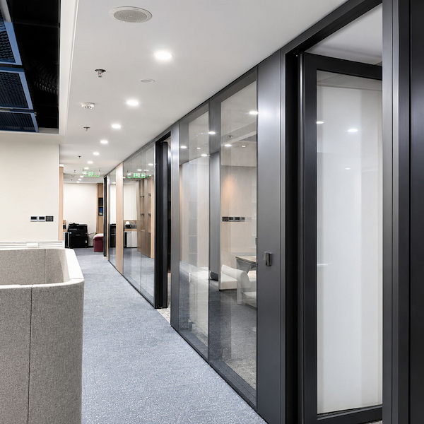 office corridor with full height glass partitions showing transparent space division and framed glass doors