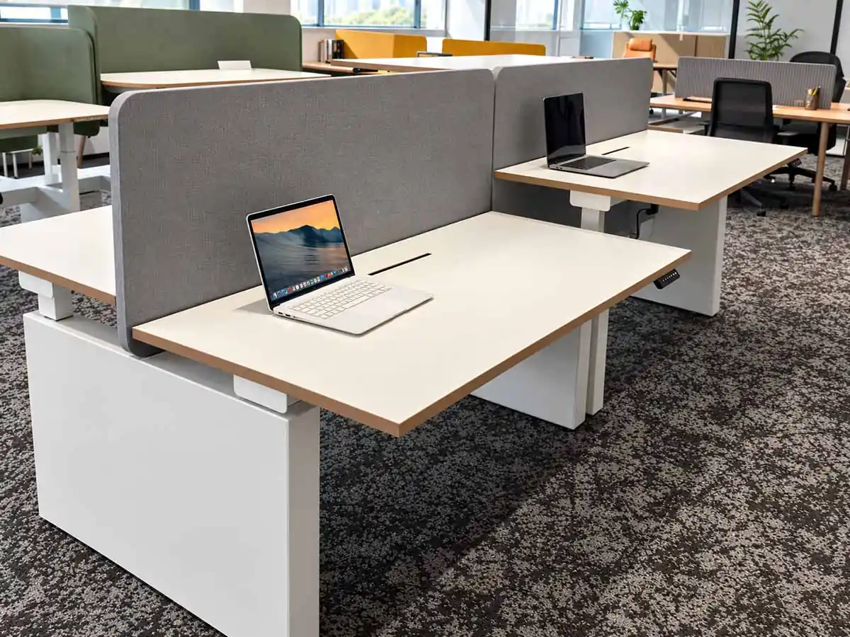 team workstations with shared desks and desk screens in an office