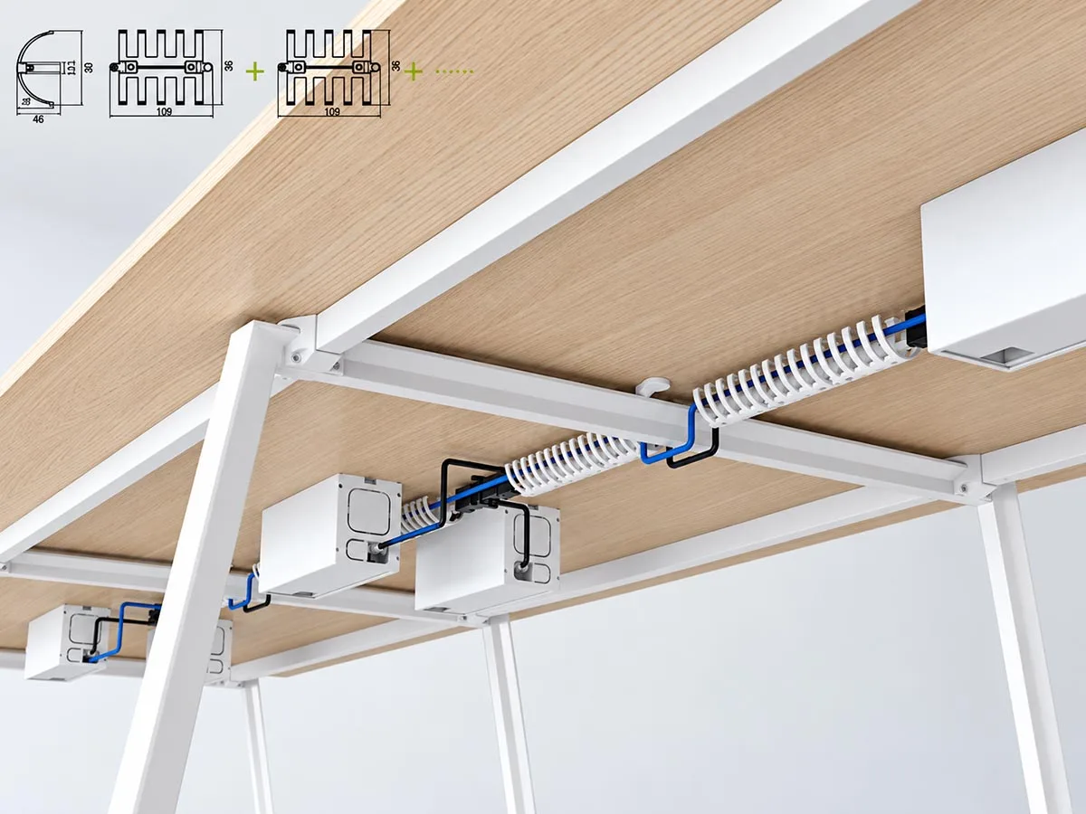 Under-desk cable management system routing power and data cables along the workstation frame