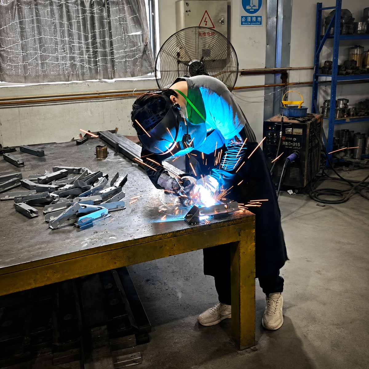 Welding process for height adjustable table frame components in a factory workshop