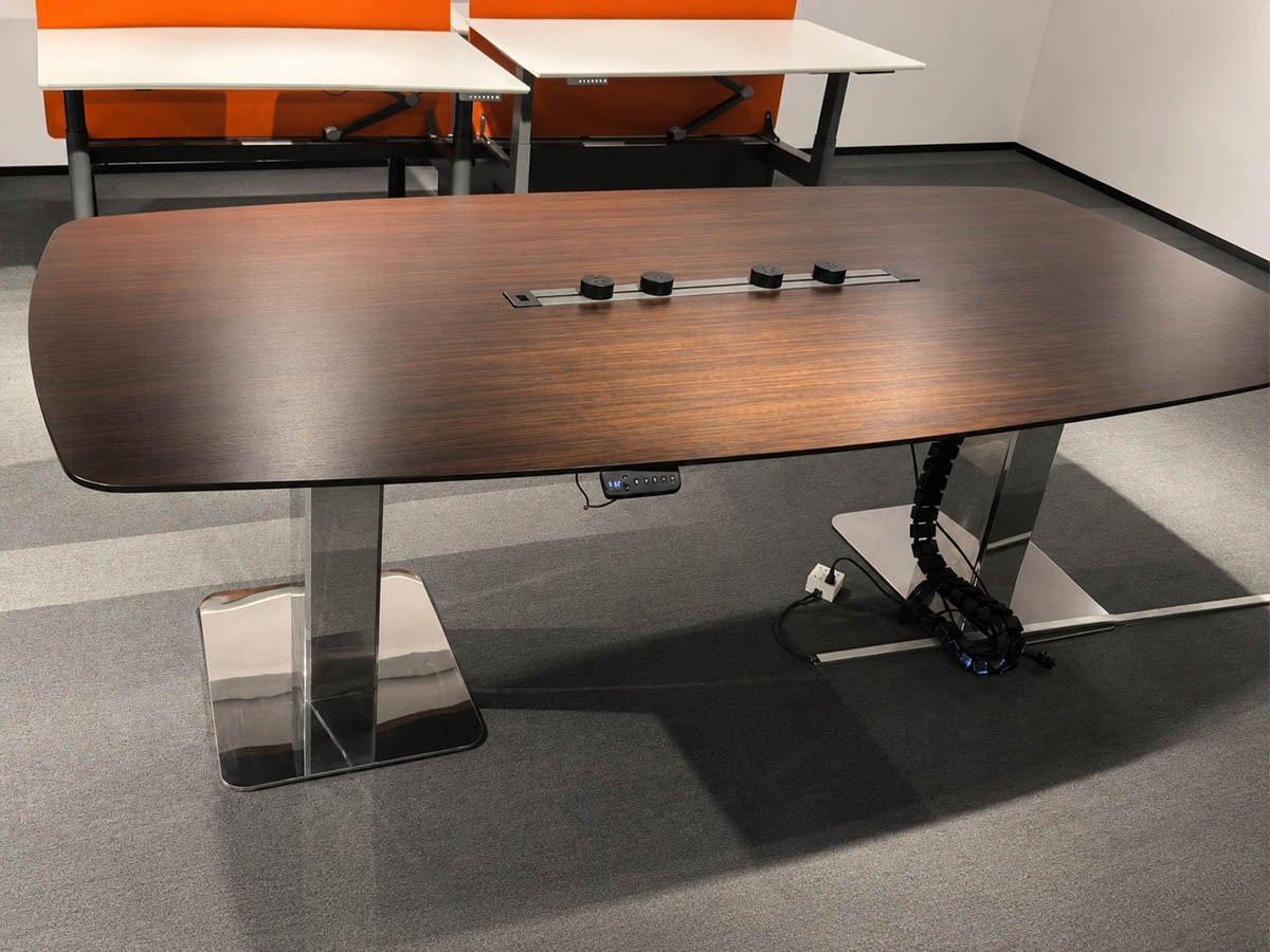 close up of a height adjustable conference table showing tabletop shape seating edge lifting supports and cable area for layout planning