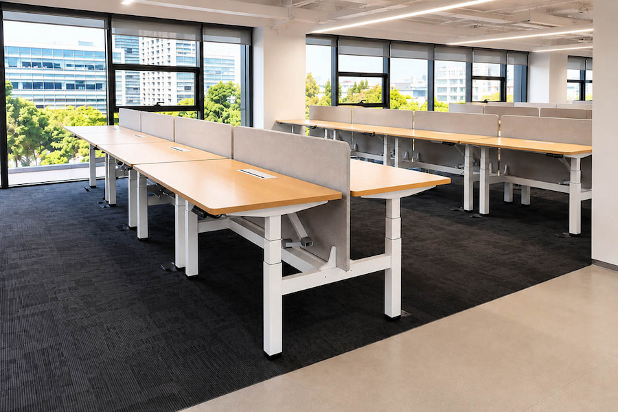 height adjustable workstation layout with multiple desks in a modern office