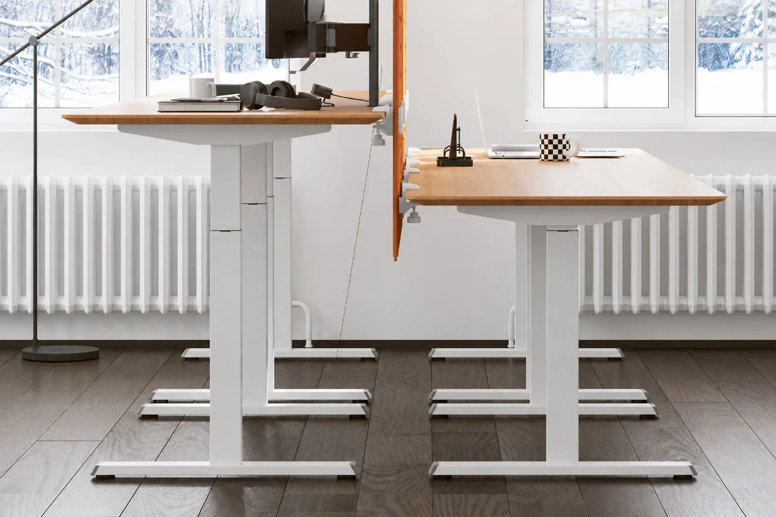 two electric height adjustable desks shown at different working heights in an office setting