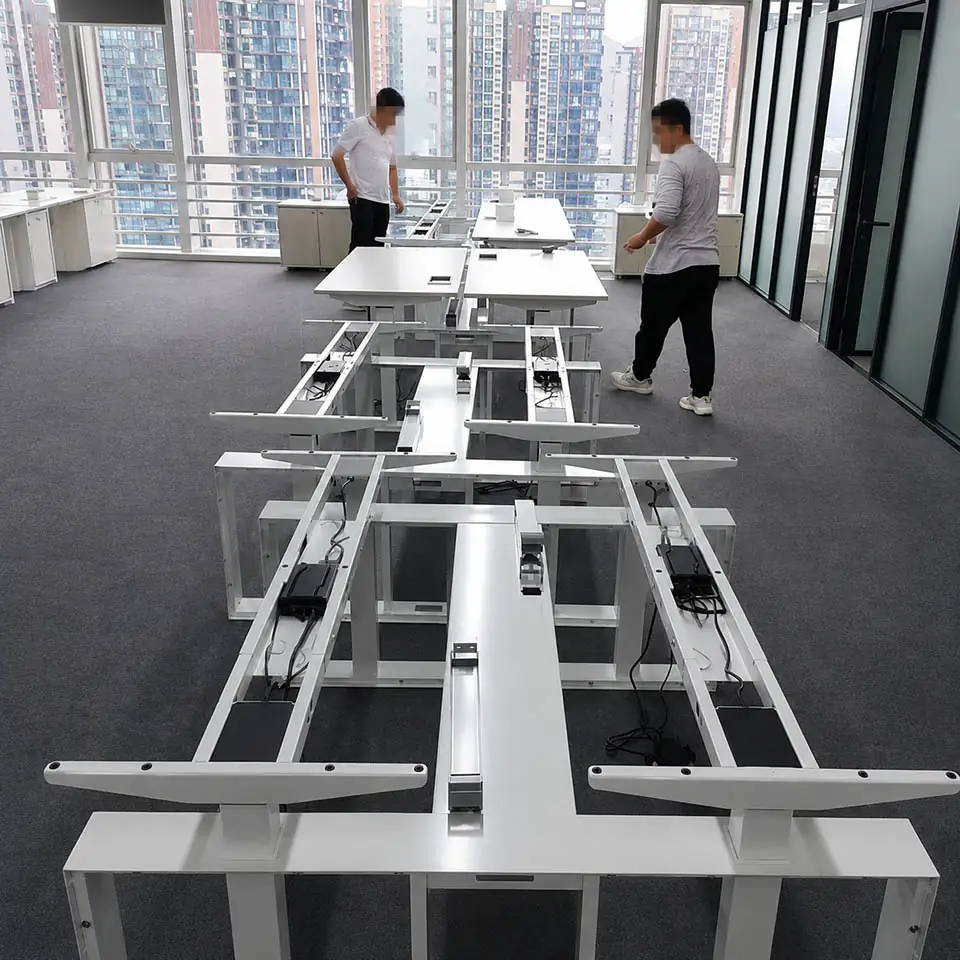 Technicians checking assembled height-adjustable desk frames during an office installation