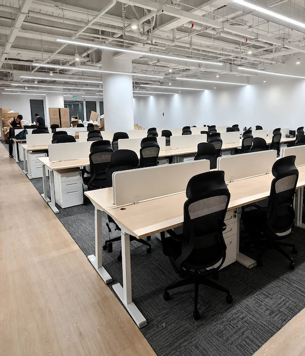 completed office with rows of height adjustable workstations privacy screens and task chairs