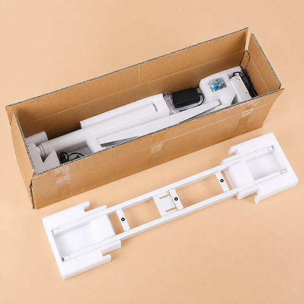 white height adjustable desk frame and components packed in a cardboard carton with protective foam