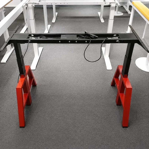 exposed height adjustable desk frame showing the crossbeam lifting columns control components and cables before the desktop is installed